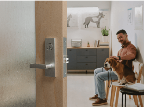 Man with dog in a waiting room, door ajar.